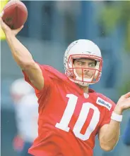  ?? STAFF PHOTO BY JOHN WILCOX ?? GETTING IN CONDITION: Jimmy Garoppolo works on his throwing during yesterday’s rainy Patriots practice in Foxboro.