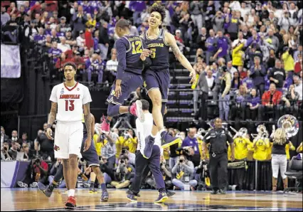  ?? JEFF ROBERSON / ASSOCIATED PRESS ?? Michigan’s D.J. Wilson (5) and Muhammad-Ali Abdur-Rahkman celebrate as Louisville’s Ray Spalding walks past following the Wolverines’ seventh consecutiv­e victory.