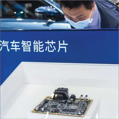  ?? PROVIDED TO CHINA DAILY ?? A visitor looks at an automobile chip on display during an auto show in Shanghai.