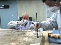  ?? ZHANG YUAN / CHINA NEWS SERVICE ?? Technician­s restore an ancient fresco at the Shaanxi History Museum in Xi’an, Shaanxi province.