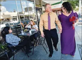  ?? JOHN WALKER PHOTOS / FRESNO BEE ?? Joe Drilling and Anna Moradian walk past the old Mia Cuppa coffee shop, now The Revue, where they first met — at a table like the one at left — after they were married at a venue at the rear of the shop, the Mia Studio and Gallery, recently.