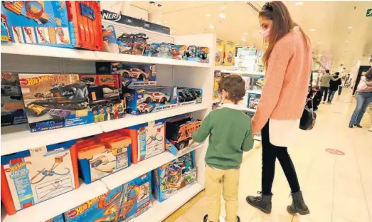  ?? ALBERTO DOMÍNGUEZ ?? Una madre y su hijo observan juguetes en una tienda de Huelva.