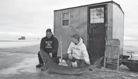  ?? PAUL A. SMITH / MILWAUKEE JOURNAL SENTINEL PAUL A. SMITH / MILWAUKEE JOURNAL SENTINEL ?? Jon Sauer (left) and his son Drew, both of Brandon, hold a 76-inch-long lake sturgeon Jon speared about 8 a.m. Saturday on Lake Winnebago. Saturday was opening day for spearing season.