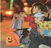  ?? JOHN RUCOSKY/THE TRIBUNE-DEMOCRAT ?? Trick-or-treaters collect candy last week in Johnstown, Pa. Some firms are trying to make it easier to recycle all those wrappers.