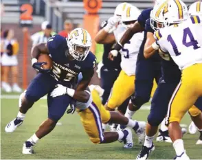  ?? STAFF PHOTO BY ERIN O. SMITH ?? UTC junior running back Tyrell Price tries to slip the grasp of a Tennessee Tech player during the Mocs’ Aug. 30 season opener at Finley Stadium.
