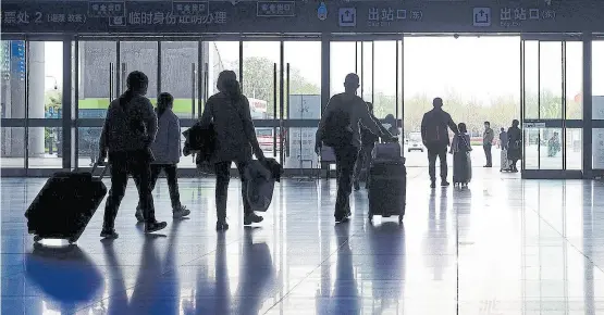  ?? Afp ?? Un grupo de pasajeros llega, ayer, a la estación de trenes de Wuhan, que lentamente recupera la normalidad