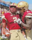  ?? STAFF PHOTOS BY STUART CAHILL ?? INTO THE RED: BC’s AJ Dillon dives for the touchdown beneath UMass safety Brice McAllister to open the scoring yesterday at Alumni Stadium. Dillon, teammate CJ Lewis (left) and the Eagles torched the Minutemen in their season debut.