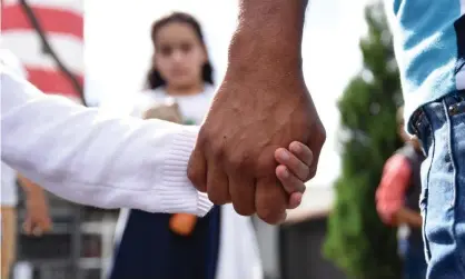  ?? Photograph: Orlando Estrada/AFP/Getty Images ?? A man holds his daughter by the hand after she and his wife were deported from the US in 2018.