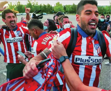  ??  ?? Suárez celebra el título con los aficionado­s del Atlético que fueron a Valladolid