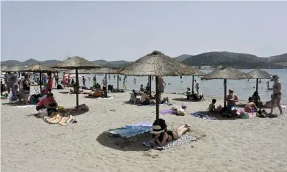  ?? Photograph: Miloš Bičanski/Getty Images ?? People enjoying the sea and sun at Anavisos beach near Athens on Saturday.