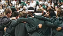  ?? ERIN KIRKLAND / NEW YORK TIMES ?? Cassius Winston (center) of Michigan State huddles with teammates earlier this month before their game against Michigan in East Lansing. Winston’s habits, and those of the Spartans, have changed after brother Zachary’s suicide in November.