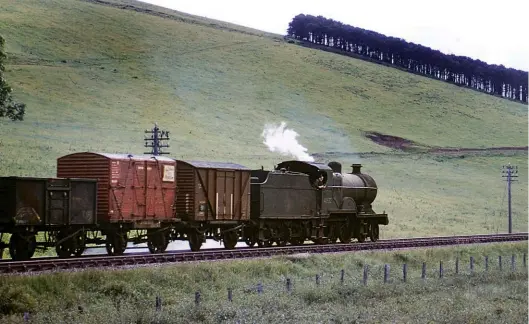  ?? T B Owen/Colour-Rail.com/394401 ?? One of the first batch of three Fowler ‘2Ps’ sent to Kittybrews­ter shed in August 1950 from Corkerhill as intended replacemen­ts for elderly GNSR 4-4-0s (with four more following in 1954/55 from Corkerhill, Hurlford, Ayr and Dundee), No 40622 was resident at Keith from 3 November 1956 and remained so until taken out of service on 11 May 1961. New from Derby Works in November 1929, this 14 June 1960 photograph records the 4-4-0 with an up goods duty, the head of the train, at least, being fitted. The photograph­er is on what was the A979 road (today’s B9002) and the high ground offering the backdrop rises to 876ft and at it peak is the ruined Dunnideer Castle of circa 1260, a tower house built on the remains of a vitrified hill fort of circa 250 BC. The train is on approach to Insch, so around 26 miles from Kittybrews­ter, its likely destinatio­n.