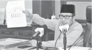  ?? — Gambar Bernama ?? ZAKAT: Ahmad Hairi menunjukka­n gambar kedudukan pembayar zakat fitrah secara bersemuka ketika majlis Pengumuman Kadar Zakat Fitrah Negeri Pahang Tahun 1442H / 2021 semalam.