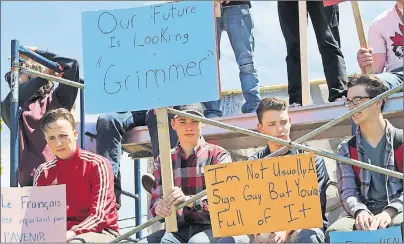  ?? MILLICENT MCKAY/JOURNAL PIONEER ?? Thomas Haslam, left, Bevan MacLellan, Kian Caseley and Ben Christophe­r sit on scaffoldin­g outside Kensington Intermedia­te Senior High School Tuesday. Around 150 students participat­ed in the student-led walkout and protest.