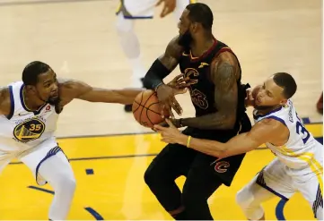  ??  ?? This file photo shows LeBron James of the Cleveland Cavaliers defending the ball next to Kevin Durant and Stephen Curry of the Golden State Warriors in Game 1 of the 2018 NBA Finals at ORACLE Arena in Oakland, California. — AFP photo