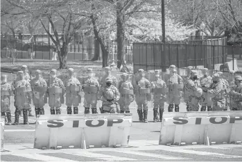  ?? DREWANGERE­R/GETTY ?? National Guard troops stand guard along Constituti­on Avenue as law enforcemen­t responds to a security incident near the U.S. Capitol on Friday in Washington, D.C. The Capitol was locked down after a driver reportedly rammed a vehicle into two Capitol Hill police officers. A suspect was apprehende­d.