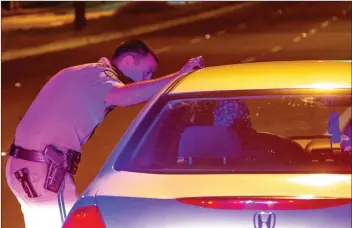  ??  ?? Perry Smith/The Signal (See additional photos at signalscv.com) California Highway Patrol Officer Josh Greengard questions a driver during a traffic stop Saturday. The CHP’s Newhall Area Office coordinate­d a “saturation patrol” with a DUI Task Force of officers from all over the CHP’s Southern Region. See A5 for more pictures.