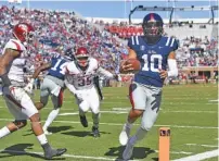  ?? THE ASSOCIATED PRESS ?? Ole Miss quarterbac­k Jordan Ta’amu, shown scoring on an 8-yard run against Arkansas in late October, guided the Rebels to three wins in five starts after replacing the injured Shea Patterson.