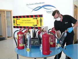  ?? REX ?? Firing on all cylinders: Extinguish­ers are checked at a school in Stockport