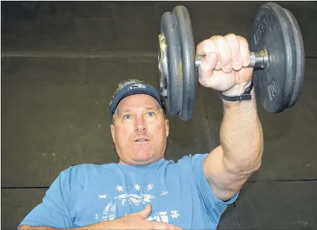  ?? KEVIN ADSHADE/THE NEWS ?? Dave MacIntyre lifts a 40-pound weight at his new performanc­e and fitness centre on the Westville Road.