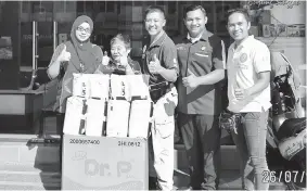  ??  ?? Hope Place founder Kelvin Wan (centre) hands over the adult diapers to Siti witnessed by Anjung Singgah officer Ediawati Apen (left).