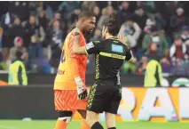  ?? ANDREA BRESSANUTT­I/ASSOCIATED PRESS ?? Referee Fabio Maresca, right, speaks to AC Milans goalkeeper Mike Maignan during the Italian Serie A soccer match between Udinese and AC Milan that was suspended in Udine, Italy, on Saturday. Racist abuse aimed at Maignan prompted a top-tier Italian league game at Udinese to be suspended briefly during the first half. Maignan left the field after the insults which followed a goal for Milan.