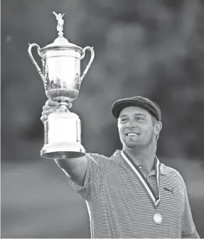  ?? DANIELLE PARHIZKARA­N/USA TODAY ?? Bryson DeChambeau celebrates with the trophy Sunday after winning the U.S. Open at Winged Foot Golf Club.