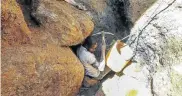  ?? Picture: AFP ?? WANTING IN: An illegal miner digs between rocks as he searches for rubies near Nthoro village in Mozambique