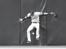  ?? Chris O’Meara/Associated Press ?? ■ Texas Rangers center fielder Carlos Tocci crashes into the wall chasing a double by Tampa Bay Rays’ Wilson Ramos during the sixth inning of a baseball game Monday in St. Petersburg, Fla.