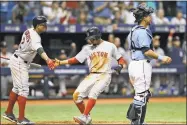  ?? Chris O’Meara / Associated Press ?? Mookie Betts, center, shakes hands with Xander Bogaerts, left, after scoring in the fifth inning against the Rays on Sunday.