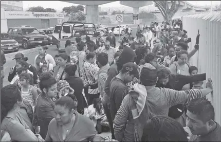  ?? AP PHOTO ?? People seeking political asylum in the United States line up to be interviewe­d in Tijuana, Mexico, just across the U.S. border south of San Diego.