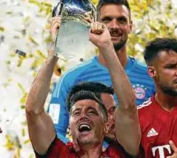  ??  ?? Seht her: Robert Lewandowsk­i hebt die Supercup-Trophäe in die Höhe. Foto: Firo