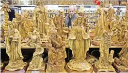  ?? AP ?? BETHLEHEM: In this Monday, Dec 12, 2016 photo, a shopkeeper walks through a souvenir shop in the West Bank city. —