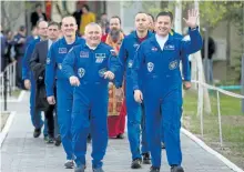  ?? GETTY IMAGES ?? Soyuz Commander Fyodor Yurchikhin of Roscosmos, left, and Flight Engineer Jack Fischer of NASA, right, wave to family and friends as they depart the Cosmonaut Hotel launch to the Internatio­nal Space Station on Thursday.