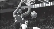  ?? REUTERS ?? Philadelph­ia 76ers center Joel Embiid (center) completes a dunk against the San Antonio Spurs on Monday.