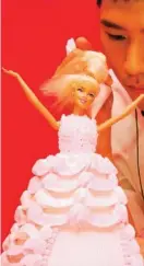  ??  ?? A chef makes a Barbie doll themed cake.