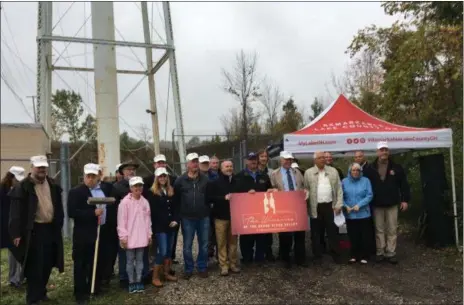  ?? BILL DEBUS — THE NEWS-HERALD ?? Organizers and guests who participat­ed in an Oct. 15 ceremony to commemorat­ing the start of on-site work for the Madison water tower restoratio­n pose for a group photo after the event in Madison Village.