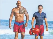  ?? FRANK MASI, SMPSP ?? Dwayne Johnson and Zac Efron are hard-bodied lifesavers and part-time superheroe­s in the comedy Baywatch.