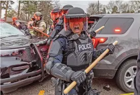  ?? (AFP) ?? Police officers take cover as they clash with protesters after an officer shot and killed a black man in Brooklyn Center, Minneapoli­s, Minnesota on Sunday