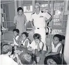  ??  ?? Navy Cmdr. McCain, top right, visits an orphanage for children fathered by American GIs in Saigon, Vietnam, in October 1974. DANG VAN PHUOC/AP