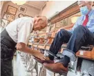  ?? MATT DAYHOFF/JOURNAL STAR ?? George Manias rubs shoe polish on Judge Mike McCuskey's shoes during a visit Thursday to George's shop in Downtown Peoria.