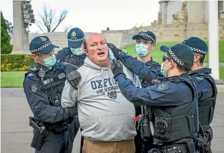  ?? NINE ?? Police try to put a mask on a man being arrested at a protest at Melbourne’s Shrine of Remembranc­e yesterday by people opposing Victoria’s coronaviru­s lockdown restrictio­ns.