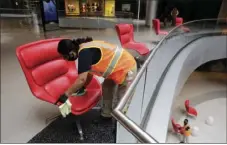  ?? AP PHOTO/DAMIAN DOVARGANES ?? Cleaning crew members, Rosalinda Venado, top, cleans and disinfects the center throughout the day, and after-hours, with a focus on high-touch, high-traffic surfaces while using a strong disinfecta­nt at the Beverly Center shopping mall in Los Angeles Friday.