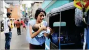  ??  ?? A Lankan woman living near St Anthony’s shrine runs for safety with her infant after police found explosive devices in a parked vehicle on Monday