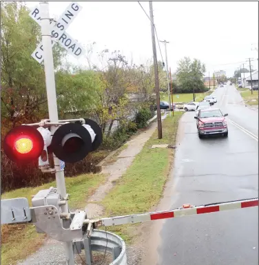  ?? Photos by Kaitlyn Rigdon/News-Times ?? Train safety: Drivers stop at a railroad crossing Wednesday, waiting for a Union Pacific train to pass.