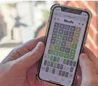  ?? IMAGES MICHAEL DRAPER/AFP VIA GETTY ?? A person plays the popular online word game “Wordle” on a mobile phone in Arlington, Va., on Monday. The New York Times removed “fetus” as its word of the day in an attempt to keep the game separate from current events.