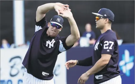  ?? Lynne Sladky / Associated Press ?? The Yankees’ Aaron Judge, left, and Giancarlo Stanton stretch before a spring training workout on Monday in Tampa, Fla.