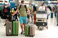  ?? The Associated Press ?? ■ A family and their pets walk through Miami Internatio­nal Airport on Monday in Miami.