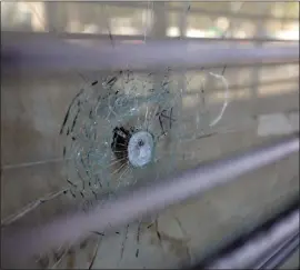  ?? ARIC CRABB — STAFF PHOTOGRAPH­ER ?? A bullet hole in a pane of glass at a business along MacArthur Boulevard in Oakland on Thursday. A mass shooting that left one dead and four others injured on Jan. 23at MacArthur and Seminary Avenue is the latest gang-related violence in Oakland.