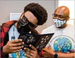  ??  ?? Kevin Freeman (left) struggles to see through special glasses while Ryan Cox watches at First Class Eye Care in Duluth. Ryan Cox founded the nonprofit Gwinnett Chatt Outreach last year.